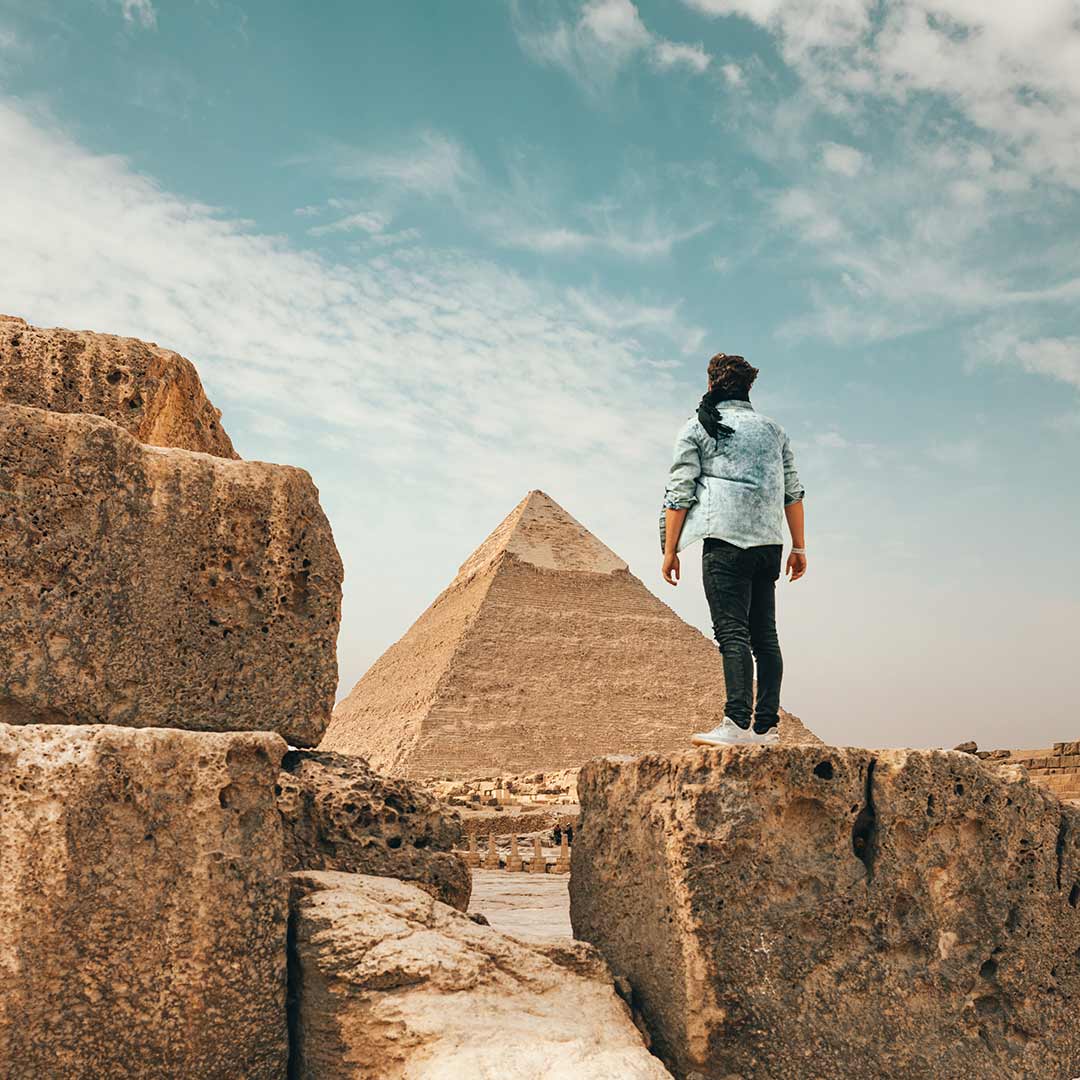 A mesmerizing view of the pyramids in Egypt, seen through the perspective of a girl gazing in awe