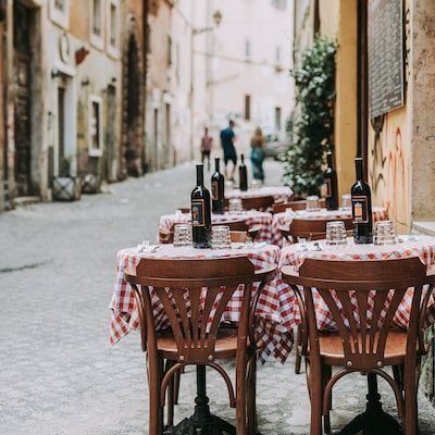 Welcoming Atmosphere: Typical Tables of an Italian Osteria in a Picturesque Alley, Your Gateway to Authentic Experiences with Dromo.